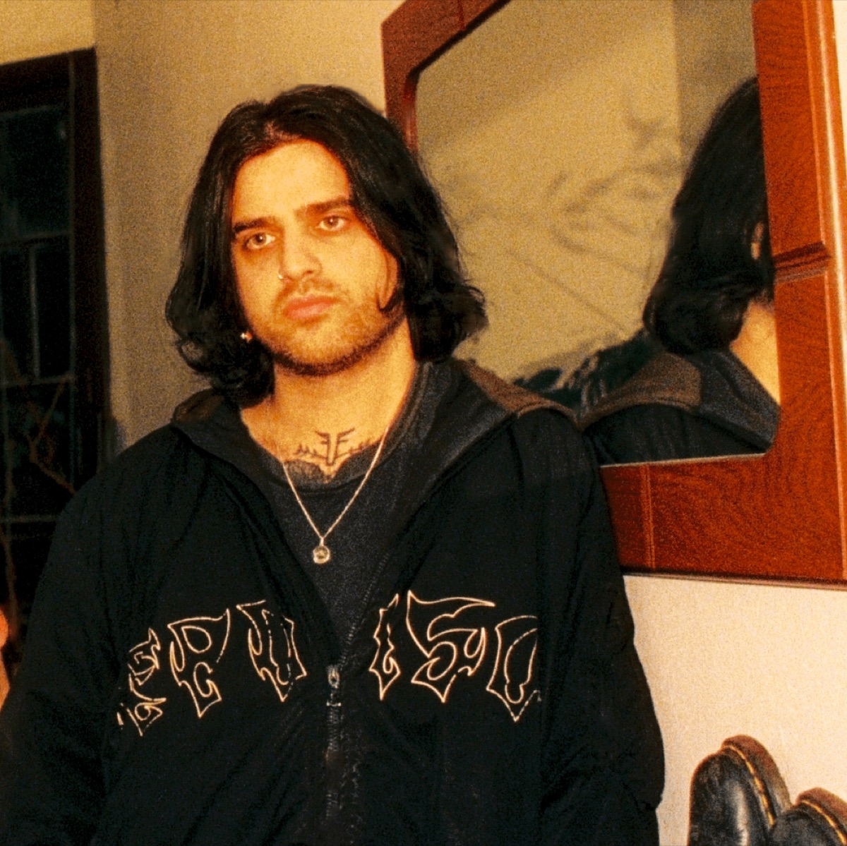 Kamran Kalantari, shoulder-length dark hair, in a black band jacket, looking straight at the camera.
